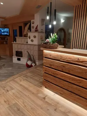 a living room with wooden floors and a kitchen at Agritur Darial in Tesero