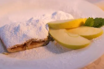a sandwich and apple slices on a white plate at Agritur Darial in Tesero