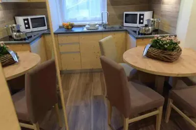 a kitchen with two tables with chairs and a counter at Agritur Darial in Tesero