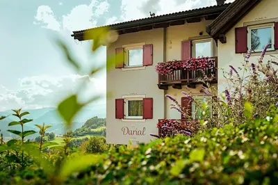 a building with a balcony with flowers on it at Agritur Darial in Tesero