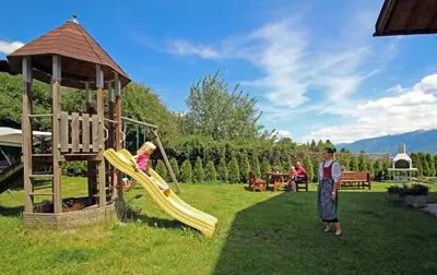 two children playing on a playground with a slide at Niederhaeusererhof in Falzes