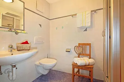 a white bathroom with a sink and a toilet at Niederhaeusererhof in Falzes