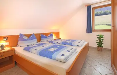a bedroom with a large bed with blue and white pillows at Niederhaeusererhof in Falzes