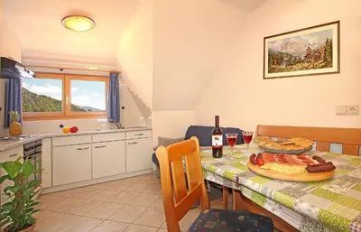 a kitchen and dining room with a table with a pizza at Niederhaeusererhof in Falzes
