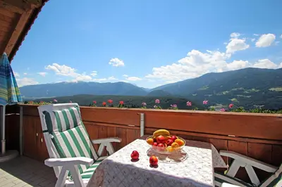 a table with a bowl of fruit on a balcony at Niederhaeusererhof in Falzes