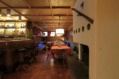 a restaurant with tables and a bar in a room at Hotel Panorama in Cavalese