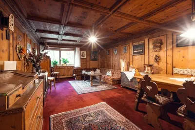 a large room with wooden walls and a living room at Hotel Panorama in Cavalese