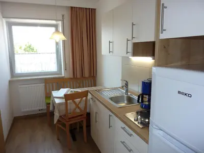a kitchen with a sink and a table with a chair at Appartement Windisch in Tirolo