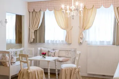 a room with a table and chairs and a chandelier at Boutique Hotel Olympia in San Vigilio Di Marebbe