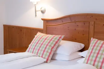 two pillows on a bed in a bedroom at Boutique Hotel Olympia in San Vigilio Di Marebbe