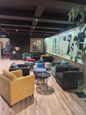 a lobby with couches and chairs and tables at Boutique Hotel Olympia in San Vigilio Di Marebbe