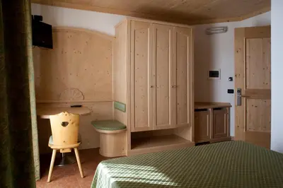 a bedroom with a bed and a desk and a chair at Agritur Scoiattolo in Coredo