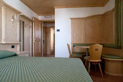 a bedroom with a bed and a desk and a table at Agritur Scoiattolo in Coredo