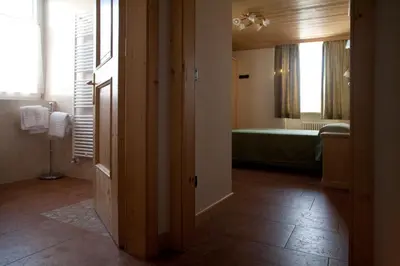 a room with a bathroom with a bed and a tub at Agritur Scoiattolo in Coredo