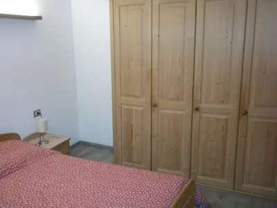 a bedroom with a bed and wooden cabinets at Casa Litegosa in Panchia