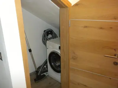 a laundry room with a washer and dryer next to a door at Casa Litegosa in Panchia