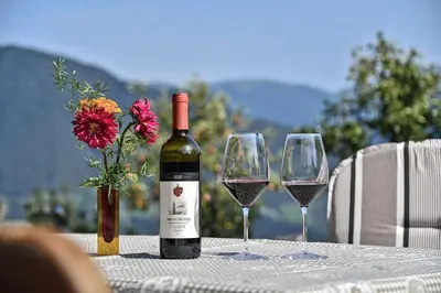 a bottle of wine and two wine glasses on a table at Apartments Schönblick in Mühlbach