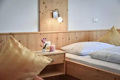 a bedroom with two beds and a table with a candle at Apartments Schönblick in Mühlbach