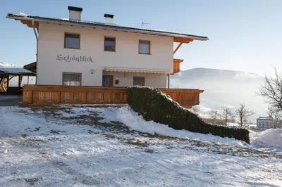 a house with a fence in the snow at Apartments Schönblick in Mühlbach