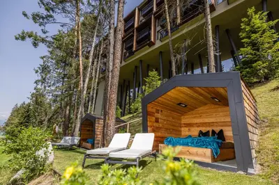 a bed and two chairs in front of a building at My Arbor - Dolomites in Bressanone