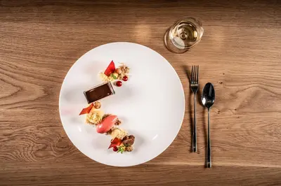 a white plate with food on a wooden table at My Arbor - Dolomites in Bressanone