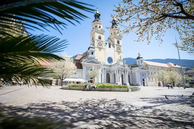 a large white building with a clock tower at My Arbor - Dolomites in Bressanone