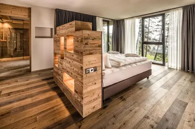 a bedroom with a large bed and wooden floors at My Arbor - Dolomites in Bressanone