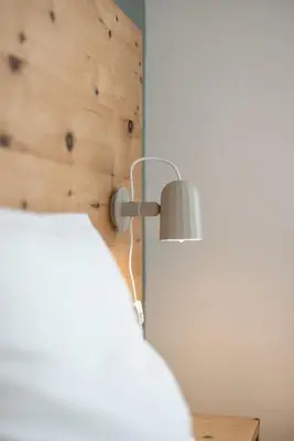 a lamp in a room with a wooden wall at Villa am Gries in Lana