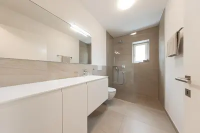 a white bathroom with a toilet and a sink at Villa am Gries in Lana