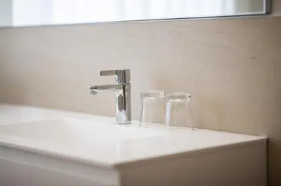 two glasses sitting on a bathroom sink with a faucet at Villa am Gries in Lana