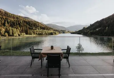 a view of a river with snow covered hills at Hotel Seehof in Monguelfo