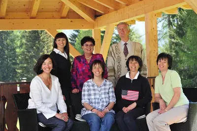 a group of people posing for a picture on a porch at Hotel Sole Family Hotel in Predazzo