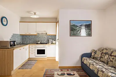 a kitchen and a living room with a couch in a room at Apartments Primula in San Vigilio Di Marebbe