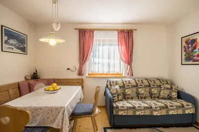 a living room with a table and a couch at Apartments Primula in San Vigilio Di Marebbe