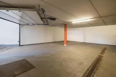 an empty room with a large white wall and an orange pole at Apartments Primula in San Vigilio Di Marebbe