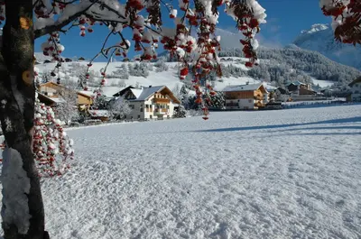 a snow covered field with houses in the background at Apartments Primula in San Vigilio Di Marebbe