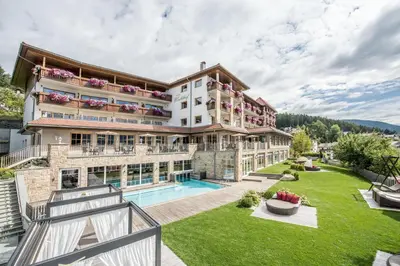 an exterior view of a building with a swimming pool at Hotel Waldhof in Perca