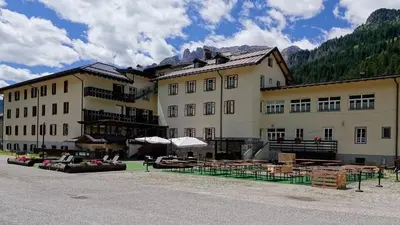 a large building with tables and chairs in front of it at Soggiorno Dolomiti in Mazzin