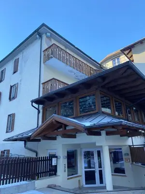 a building with a balcony on top of it at Soggiorno Dolomiti in Mazzin