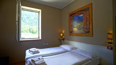 a bedroom with a bed and a window with towels at Soggiorno Dolomiti in Mazzin