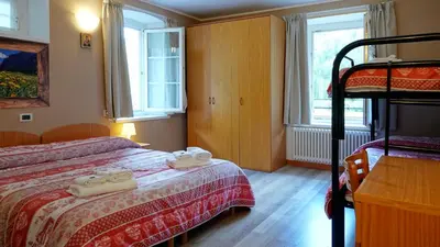 a bedroom with two beds and a bunk bed at Soggiorno Dolomiti in Mazzin