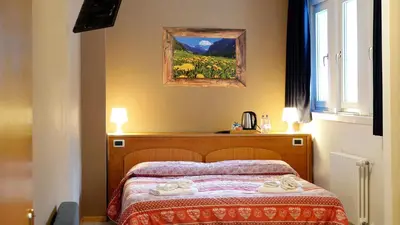 a bedroom with a bed with two towels on it at Soggiorno Dolomiti in Mazzin