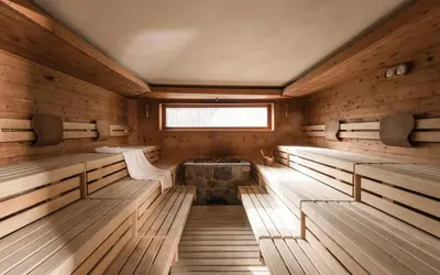 an interior of a sauna with benches and a window at Hotel Pider in La Valle