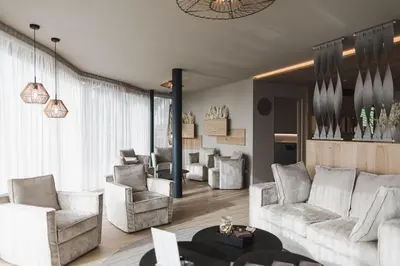 a bedroom with a four poster bed and a living room at Hotel Hubertus in Valdaora