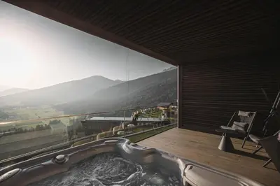 a house on top of a mountain with a view at Hotel Hubertus in Valdaora