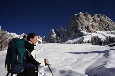a man on skis in the snow in front of a mountain at Hotel Piné in Tires