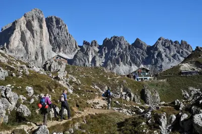 a group of people walking on a mountain at Hotel Piné in Tires