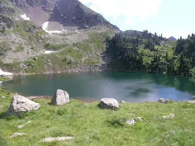 a lake in the middle of a mountain with rocks at B.& B. Corradini in Castello di Fiemme