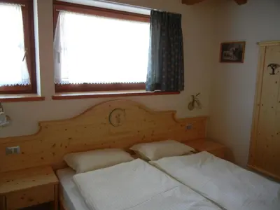 a bedroom with two beds and a window at B.& B. Corradini in Castello di Fiemme