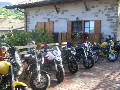 a row of motorcycles parked in front of a house at B.& B. Corradini in Castello di Fiemme